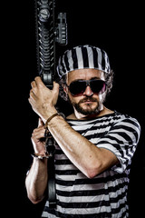 Security.Prison riot concept. Man holding a machine gun, prisone