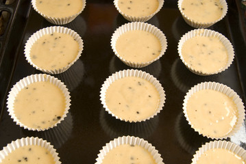 Raw dough into muffins in the forms .