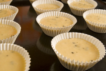 Raw dough into muffins in the forms .