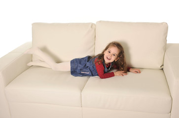 Obraz premium happy adorable little girl with long hair lying on couch playful