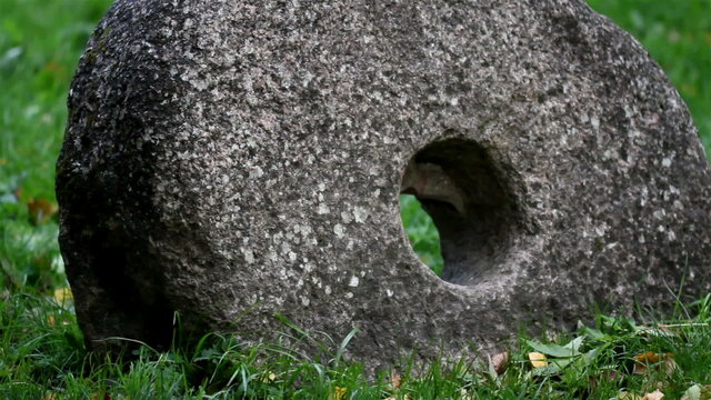 Big millstone grindstone rock with a hole at the center