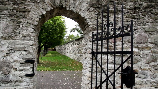 Stone entrance with an old medieval black steel gate
