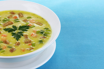 Tasty soup on blue tablecloth isolated on white