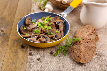 Delicious fried mushrooms in pan on table close-up