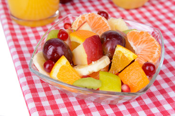 Sweet fresh fruits in bowl on table close-up