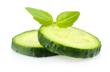 Sliced fresh cucumber with basil, isolated on white