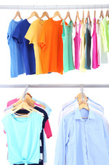 Different clothes on hangers, on gray background
