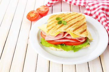Tasty sandwich with ham on wooden table