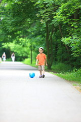 Boy kicks the ball in park outdoors