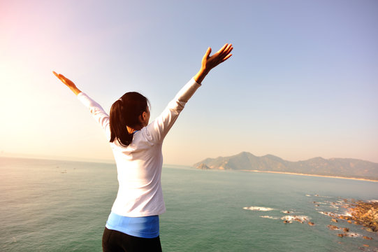 cheering woman open arms seaside mountain