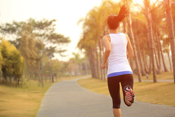 fitness young woman jogging at tropical park - obrazy, fototapety, plakaty