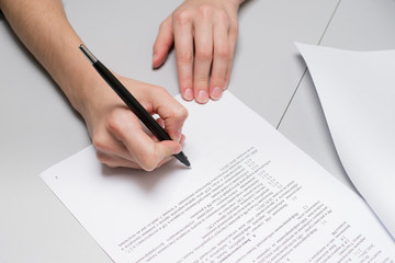 Closeup of a human hand signing a business contract on the foreground