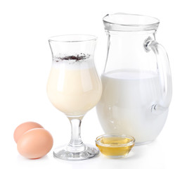 Eggnog with milk and eggs isolated on white