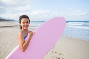 Naklejka na ściany i meble Happy young girl with surfboard