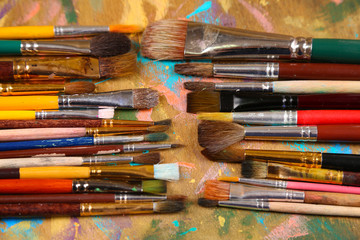 Fototapeta premium Brushes on multicolor wooden background