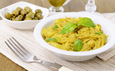 Delicious pasta with pesto on plate on table close-up