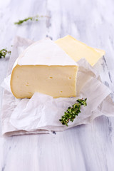 Tasty Camembert cheese with thyme, on wooden table