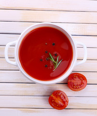 Tasty tomato soup on wooden table