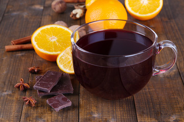 Mulled wine with orange and spices on wooden background