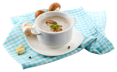 Mushroom soup in white pot, on napkin, isolated on white
