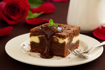 Chocolate brownie with cheese filling and chocolate sauce.