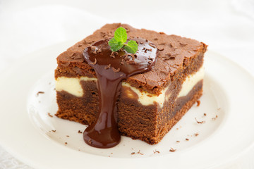 Chocolate brownie with cheese filling and chocolate sauce.