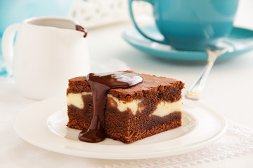 Chocolate brownie with cheese filling and chocolate sauce.