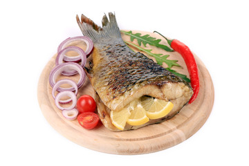 The tail of fried fish on a wooden plate
