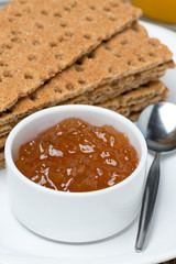 close-up of orange jam and crisp bread, vertical
