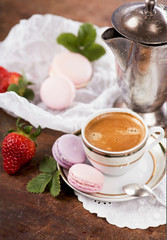 Coffee and French macaroons on a wooden background