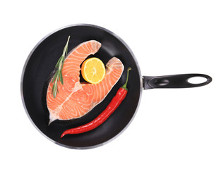 Salmon steak on pan with pepper.