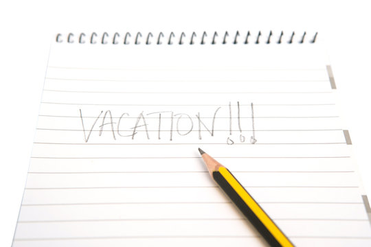 Concept image of the word vacation on a notepad with pencil