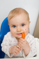 baby eating carrots at home, all soiled vegetables, healthy nutr