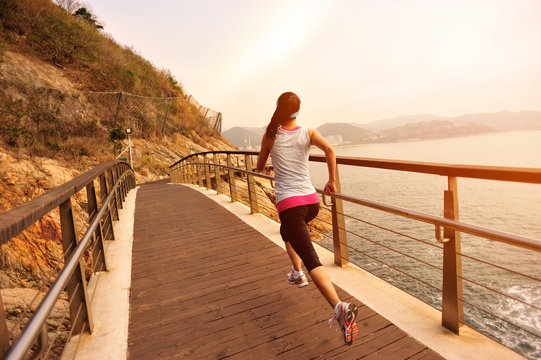 healthy lifestyle sports woman running on wooden bridge seaside 