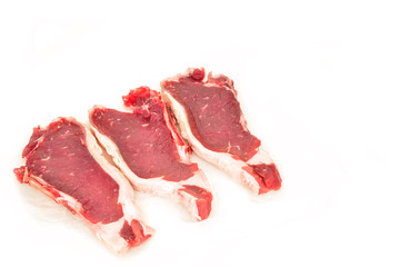 three Spanish beef steaks on paper isolated