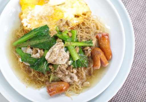 Chinese style deep fried yellow noodles with pork and fried egg