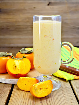 Milkshake with persimmons in goblet on board