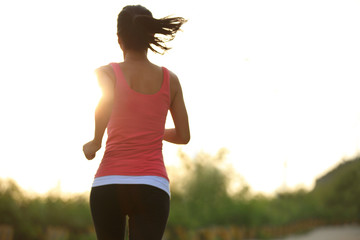 fitness woman jogging at sunrise mountain driveway