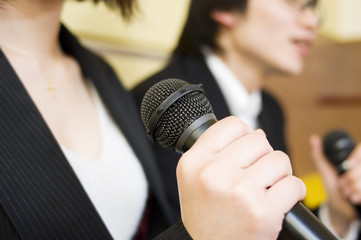 man and woman holding microphone in their hand