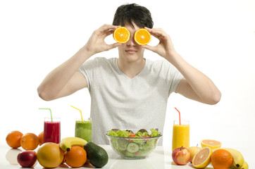 Happy man holding in front of his eyes oranges, organic raw food