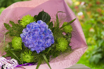 Blue and green bouquet of flowers wrapped in paper
