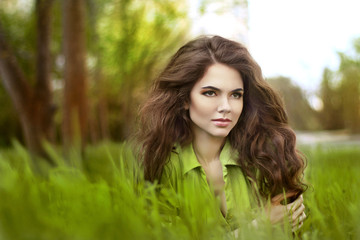 Naklejka premium Teen girl resting over green field of grass, springtime. Nature