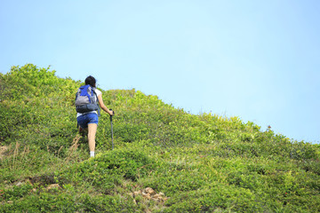 Naklejka na ściany i meble cheering woman hiker open arms at seaside mountain peak