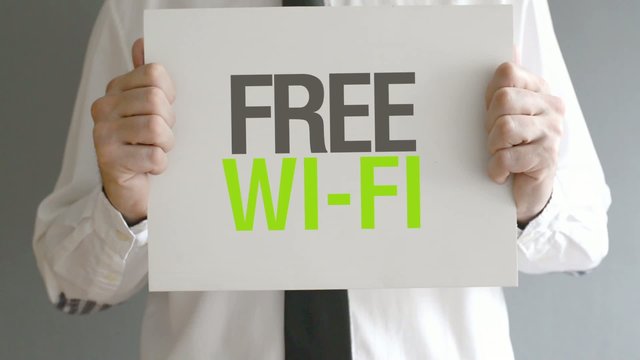 Businessman holding paper with Free Wi-Fi title.