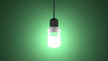 Glowing spiral light bulb hanging on green
