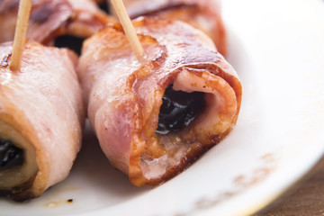 Baked prunes in bacon on a plate