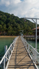 Fototapeta na wymiar деревянный мост с фонарями на тропический пляж
