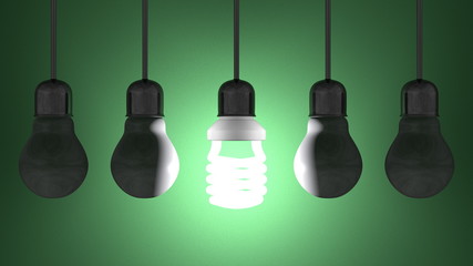 Glowing spiral light bulb, dead tungsten ones hanging on green