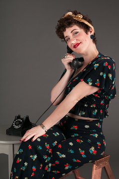 Pinup Girl in Flowered Outfit Smiles Gently on the Phone