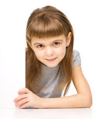 Little girl is looking out from the blank banner